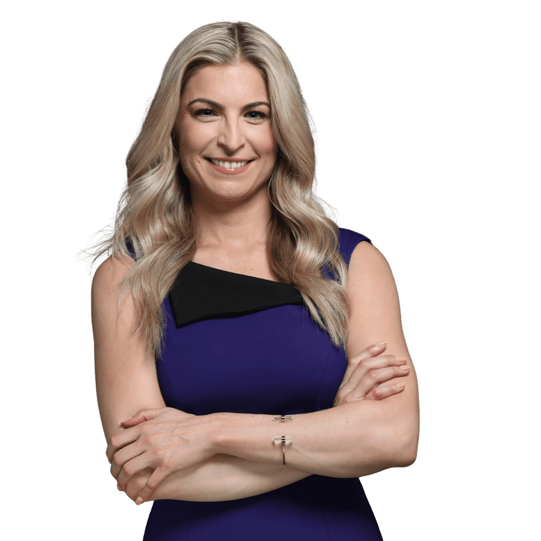 A woman with long, wavy blonde hair wearing a sleeveless blue dress with a black detail, smiling and standing with her arms crossed, radiates happiness and wellbeing.