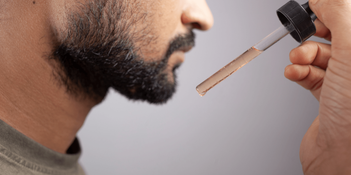 A man applying minoxidil for beard growth.