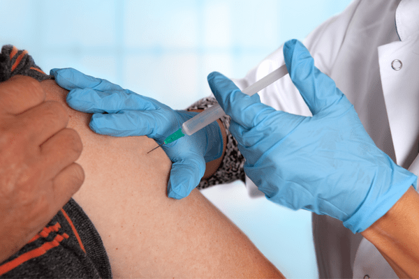 A close-up of an injection into a person's upper arm.