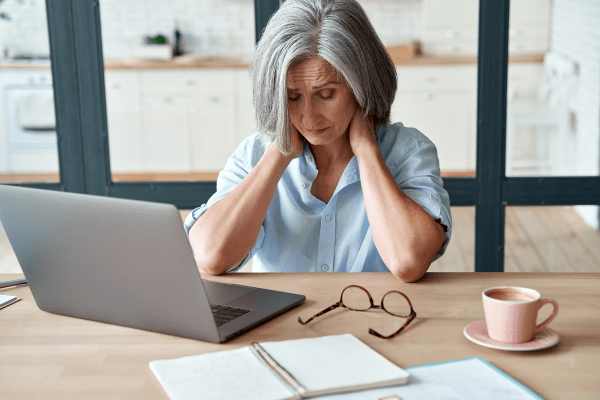 A tired older woman using a computer