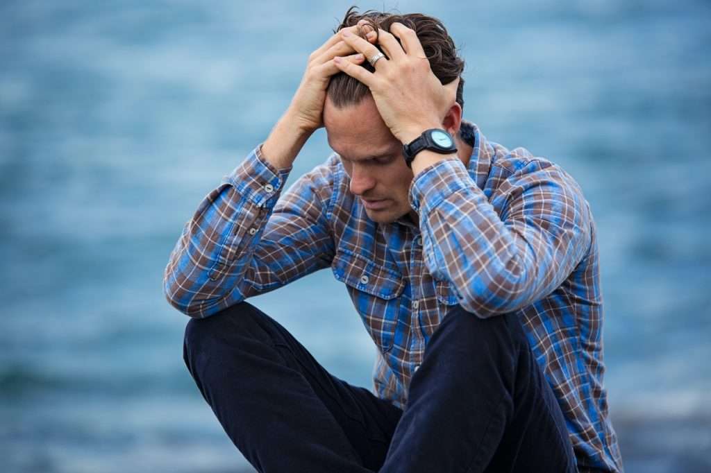 A man in distress, hands on head