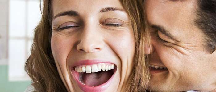 A man whispering in a woman's ear